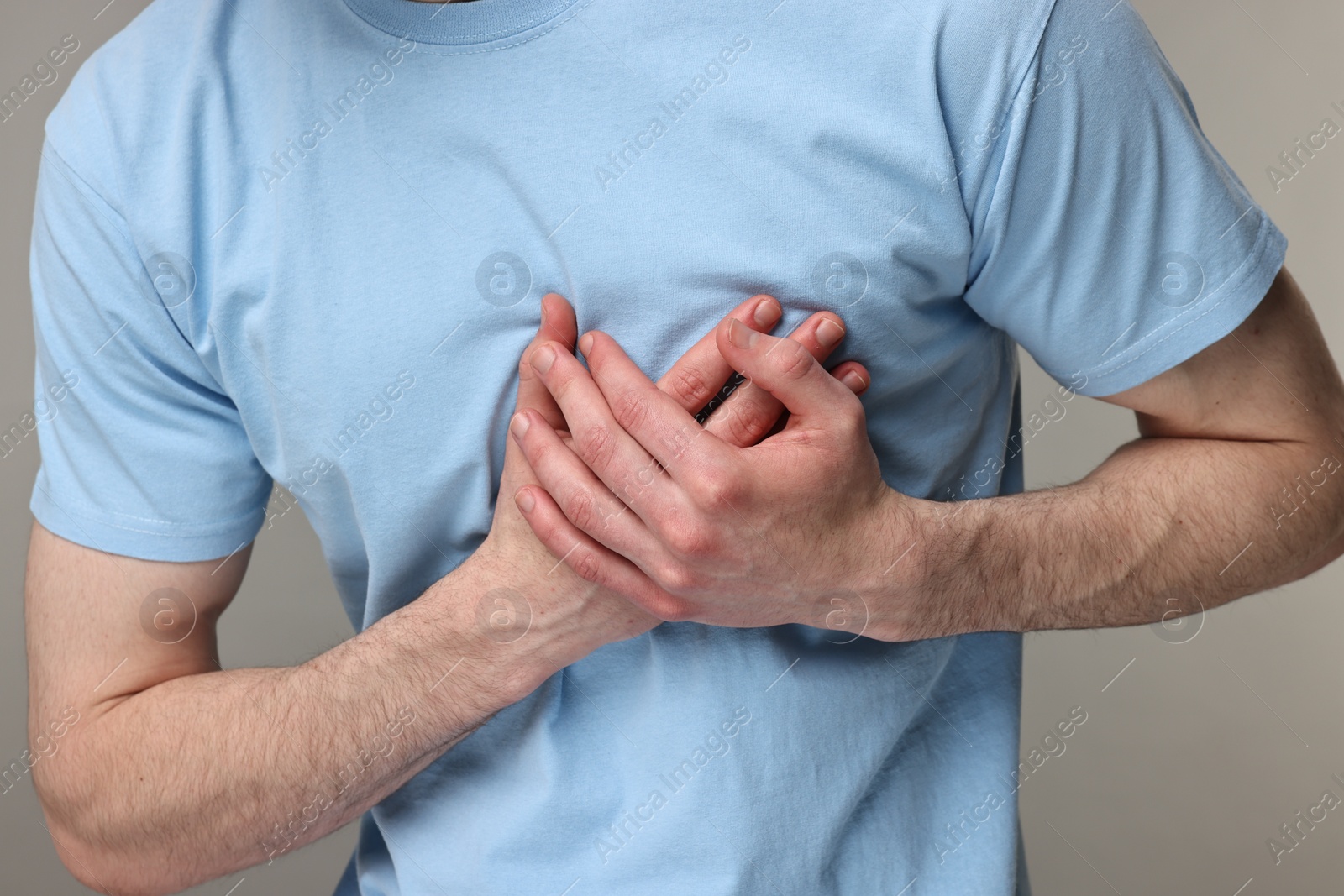 Photo of Man suffering from heart hurt on grey background, closeup