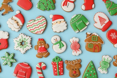 Different Christmas gingerbread cookies on light blue background, flat lay