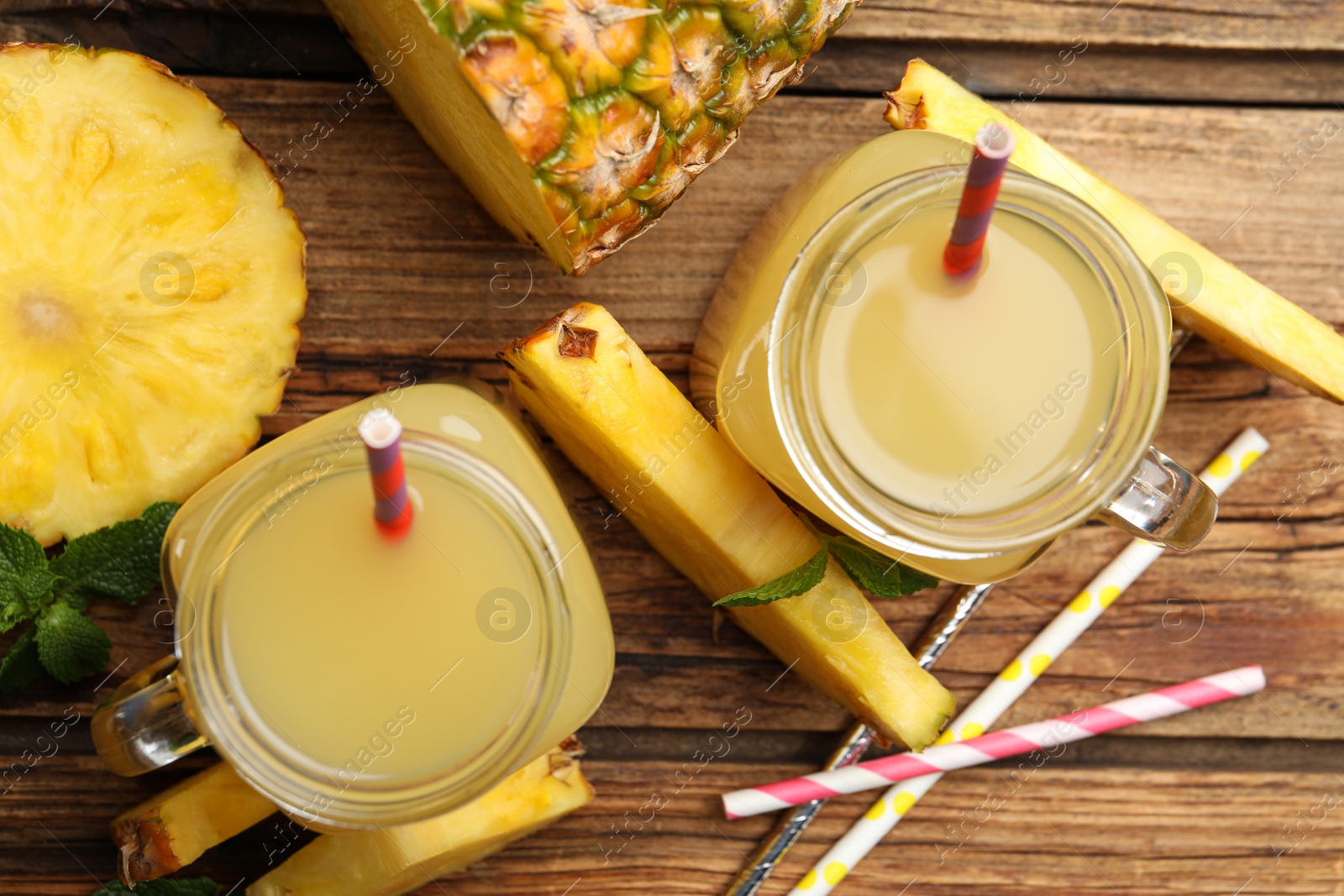 Photo of Delicious pineapple juice and fresh fruit on wooden table, flat lay