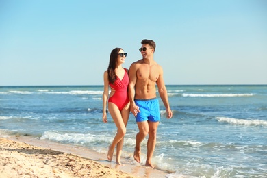 Happy young couple walking together on beach