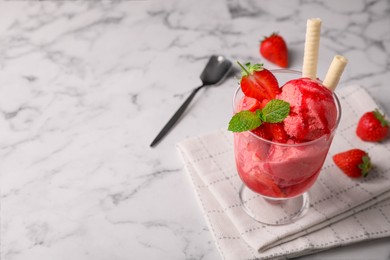 Photo of Tasty strawberry ice cream with fresh berries and wafer rolls in glass dessert bowl on white marble table. Space for text