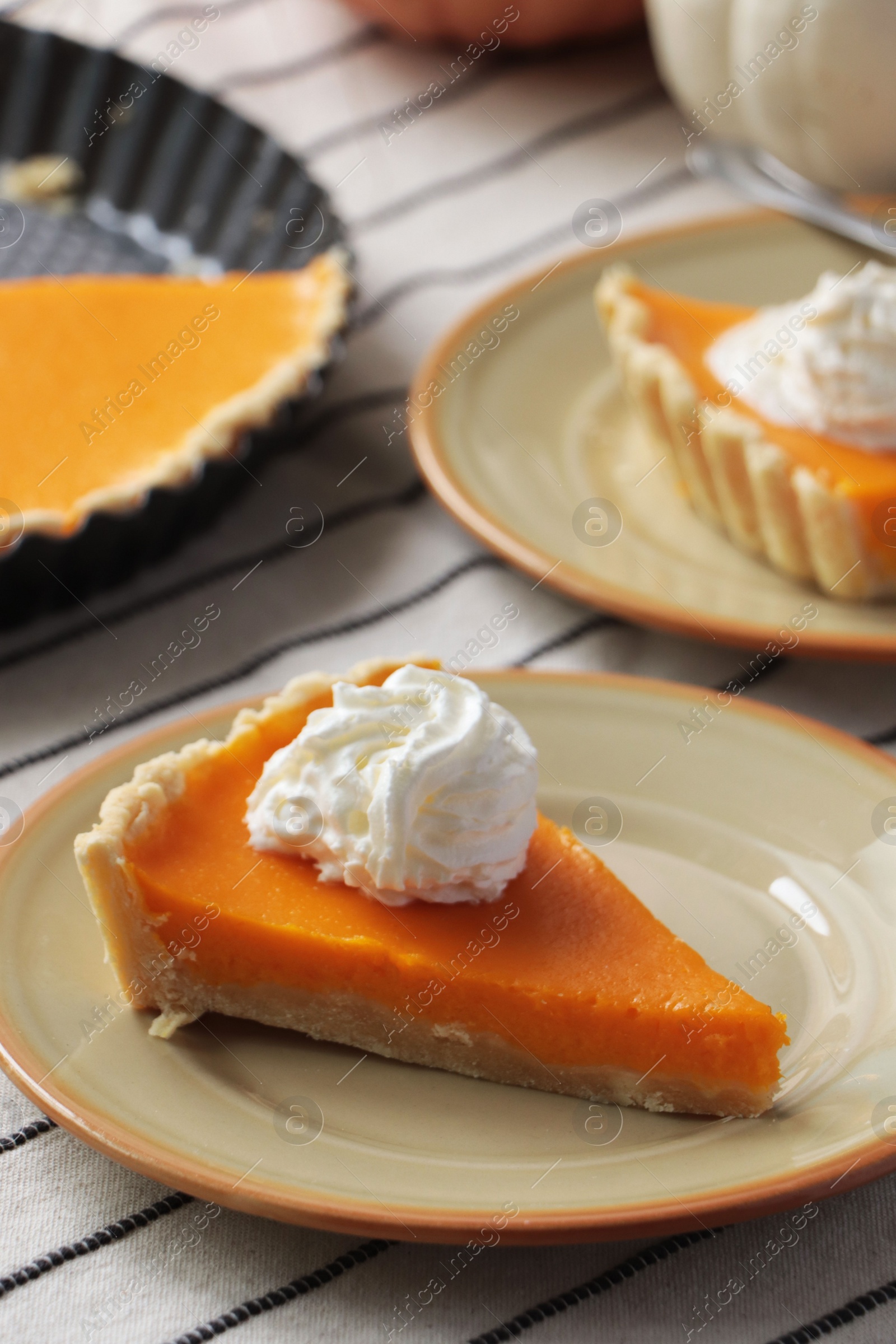 Photo of Fresh homemade pumpkin pie with whipped cream on table