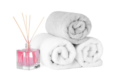 Photo of Clean towels and air freshener isolated on white. Spa treatment