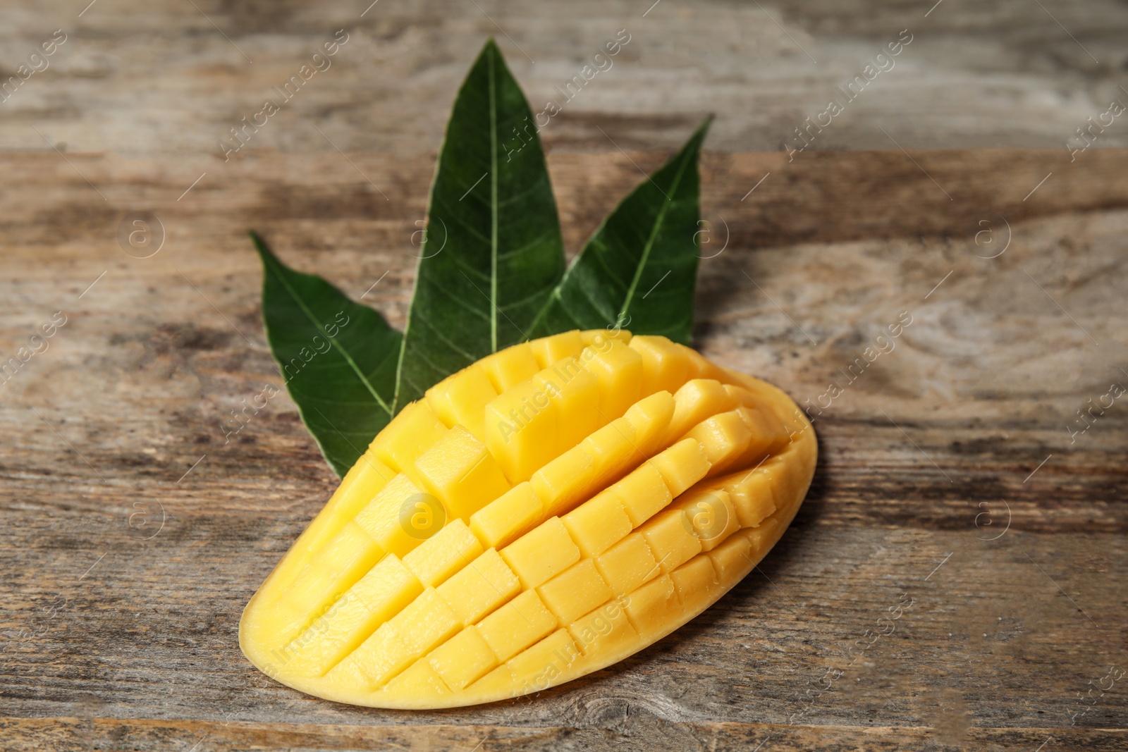 Photo of Ripe juicy mango on wooden table. Tropical fruit