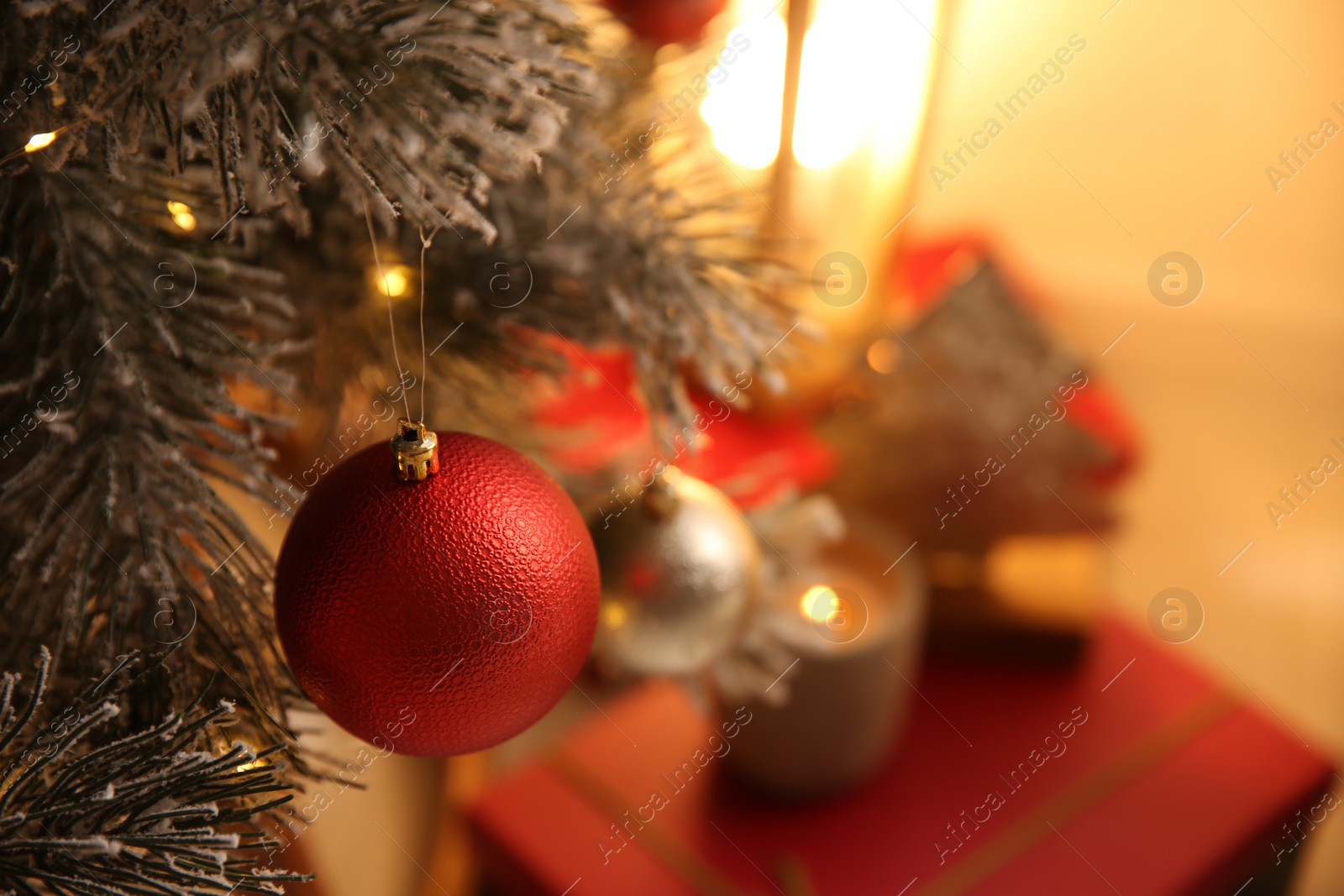 Photo of Red bauble hanging on Christmas tree indoors, space for text