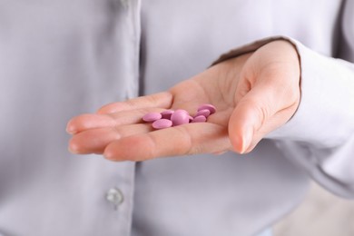 Photo of Woman holding pile of pink antidepressants, closeup view