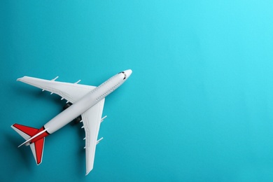 Photo of Toy airplane on light blue background, top view. Space for text