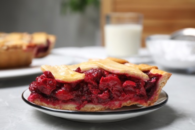 Photo of Piece of delicious fresh cherry pie on light grey marble table, closeup