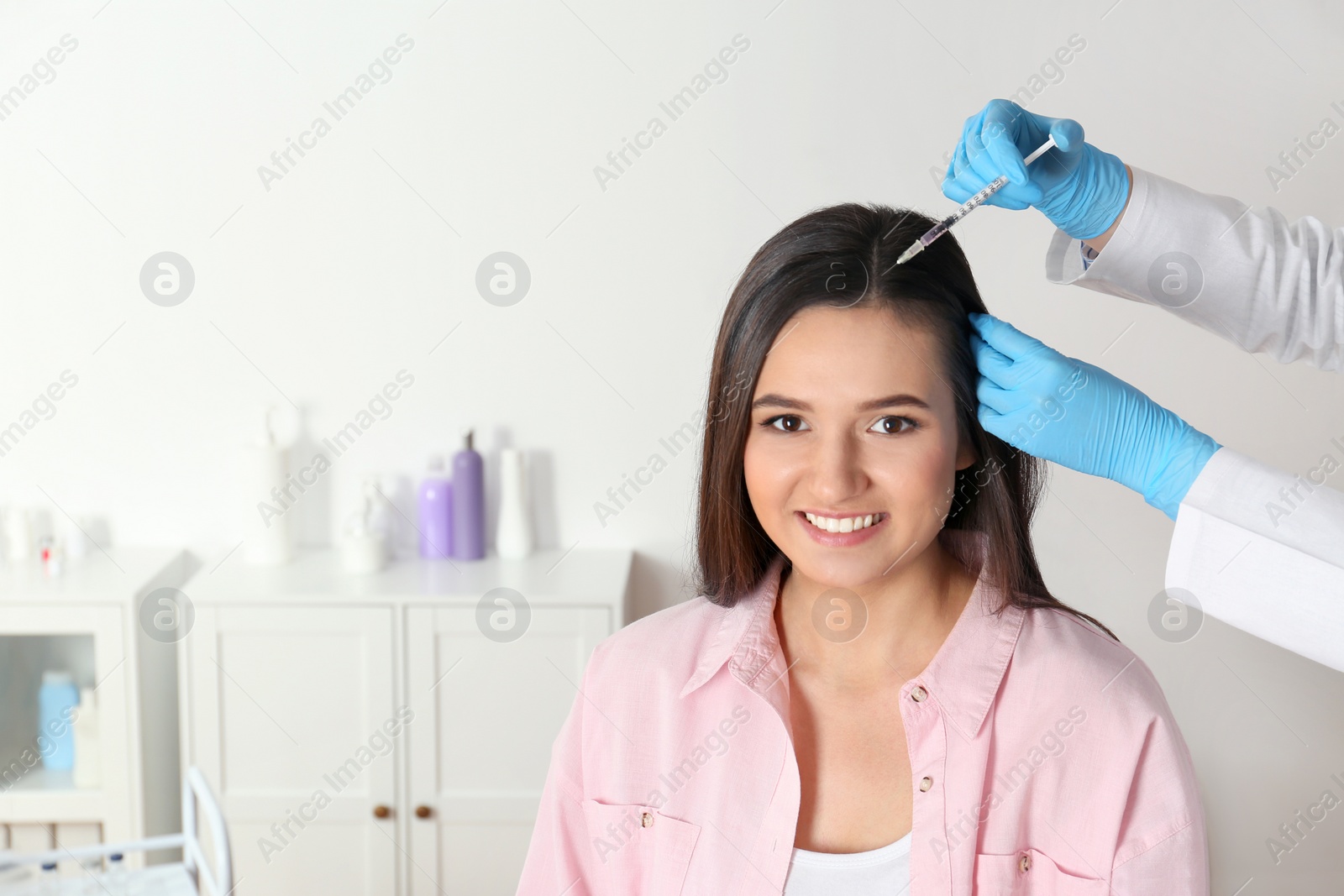 Photo of Young woman with hair loss problem receiving injection in salon