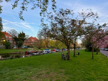 Beautiful view of canal with different boats near green lawn