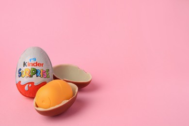 Photo of Slynchev Bryag, Bulgaria - May 25, 2023: Kinder Surprise Eggs and plastic capsule with toy on pink background, space for text