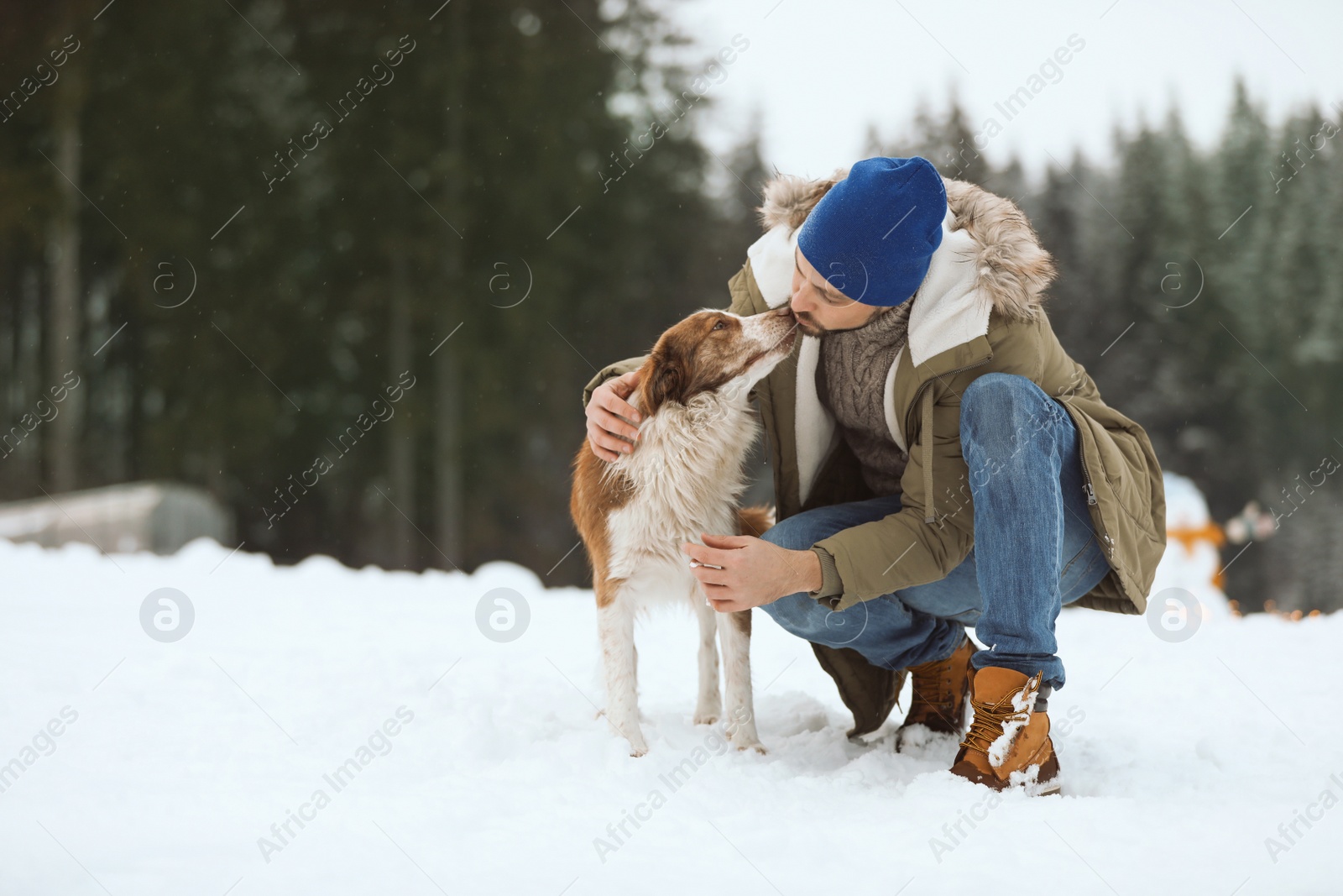 Photo of Man with cute dog near forest. Winter vacation