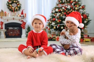 Photo of Cute little children with toys in room decorated for Christmas