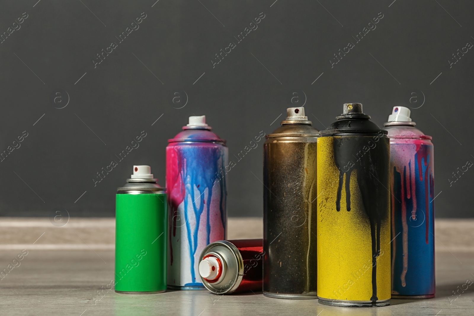 Photo of Used cans of spray paint on floor indoors