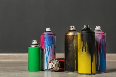 Photo of Used cans of spray paint on floor indoors