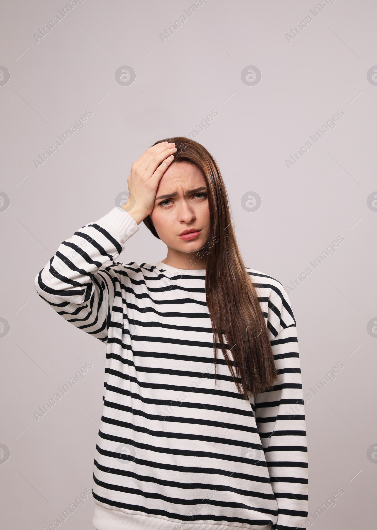 Photo of Woman suffering from headache on light grey background. Cold symptoms