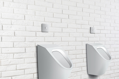 Image of Clean ceramic urinals in men's public bathroom