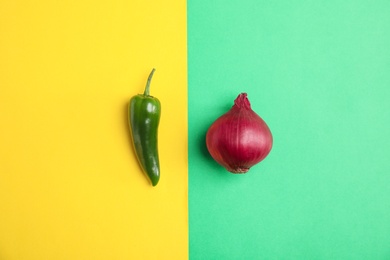 Beautiful composition with ripe red onion and pepper on color background