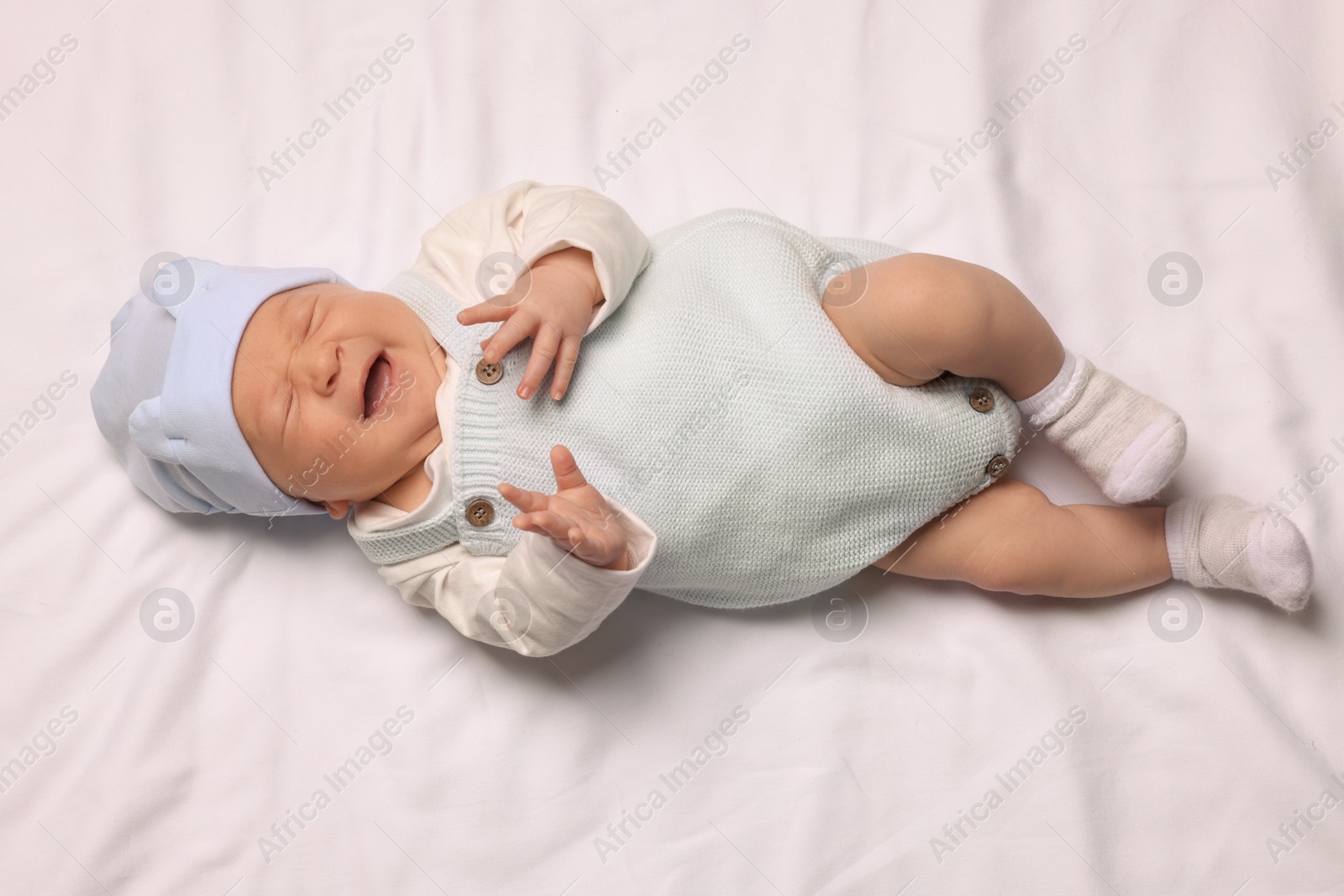Photo of Cute newborn baby lying on white blanket, top view