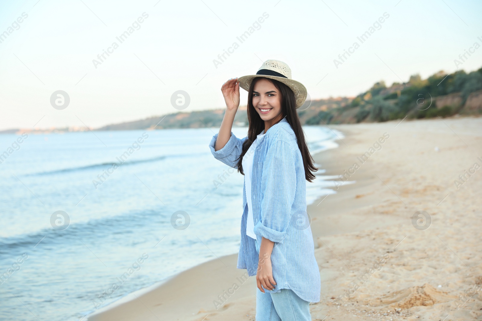 Photo of Beautiful young woman in casual outfit on beach