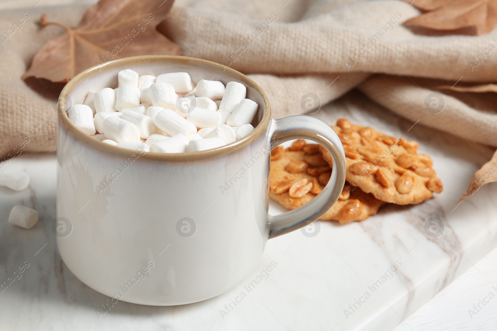 Photo of Cup of hot cozy drink, tasty cookies and  autumn leaves on table