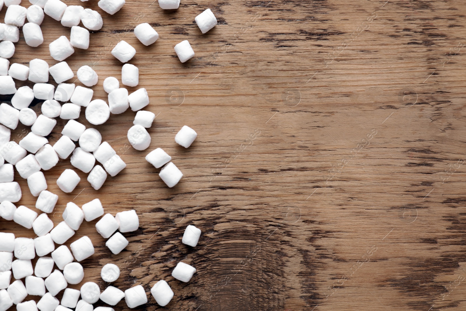 Photo of Delicious marshmallows on wooden table, flat lay. Space for text