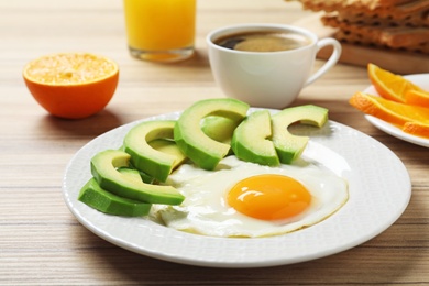 Delicious breakfast with fried egg served on wooden table