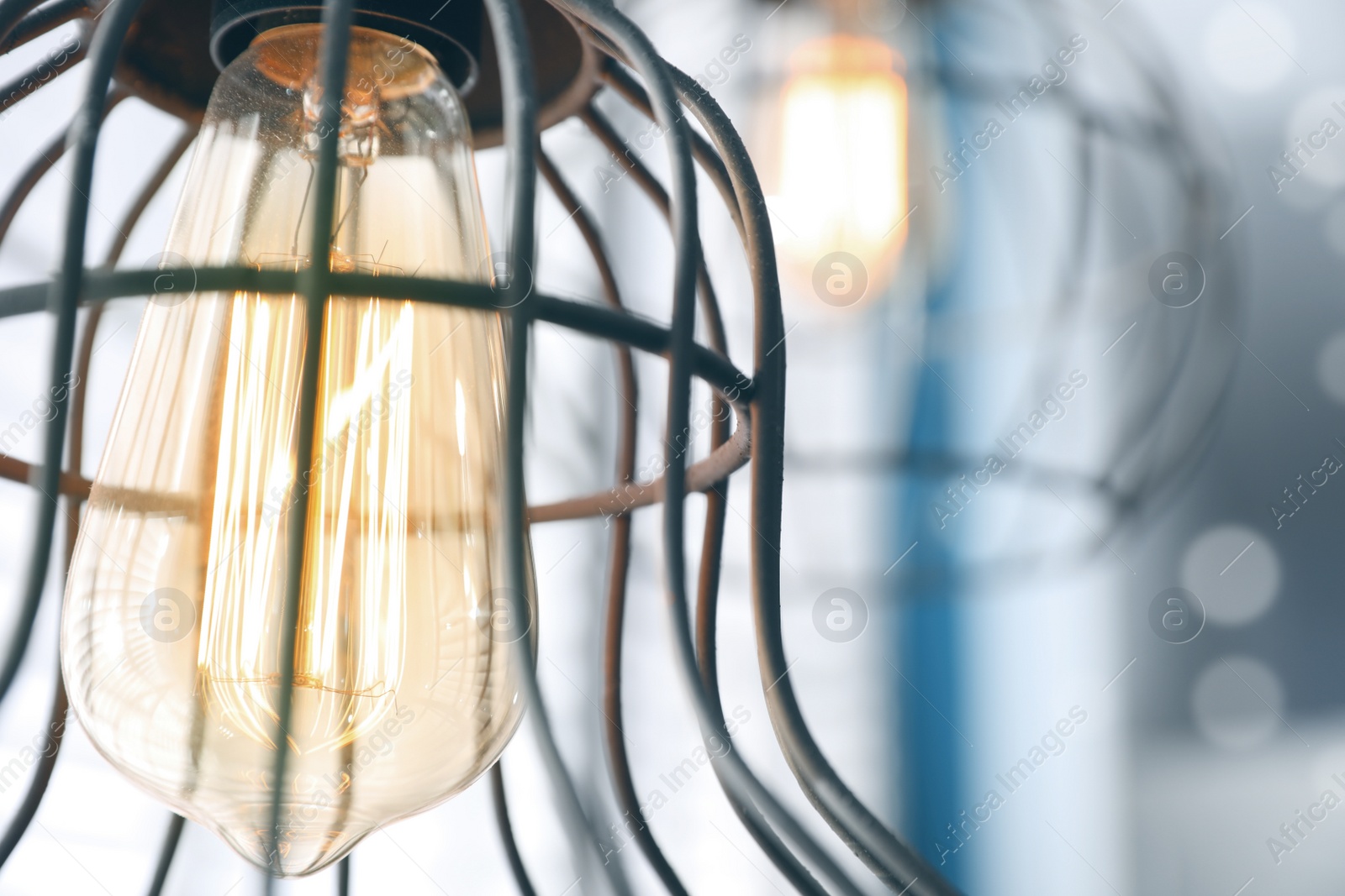 Image of Stylish metallic pendant lamp with Edison light bulb indoors, closeup