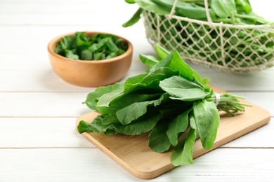 Photo of Fresh green sorrel leaves on white wooden table, closeup