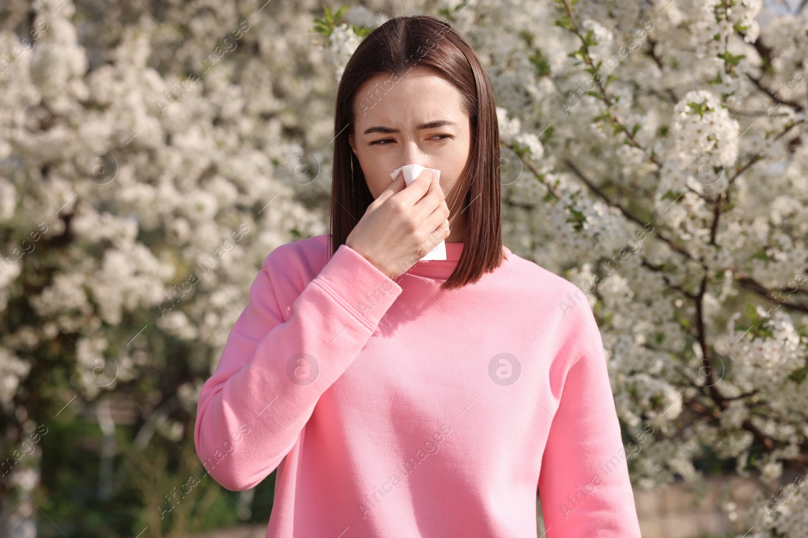 Photo of Woman with napkin suffering from seasonal allergy on spring day