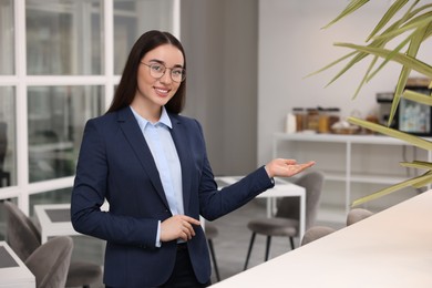 Happy female real estate agent in office