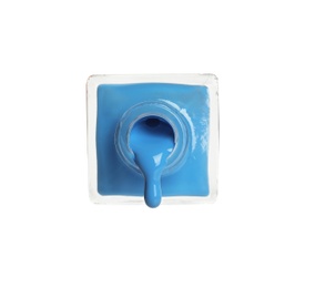 Photo of Pouring color nail polish from bottle on white background