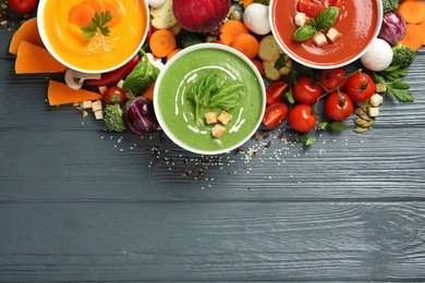 Various cream soups, ingredients and space for text on wooden background, flat lay. Healthy food