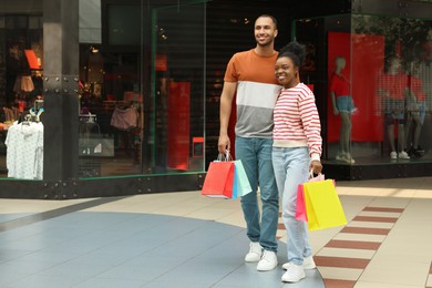 Family shopping. Happy couple with colorful bags in mall