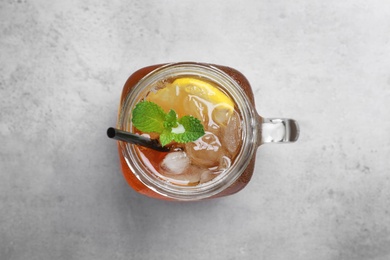 Photo of Delicious iced tea with lemon and mint on grey table, top view