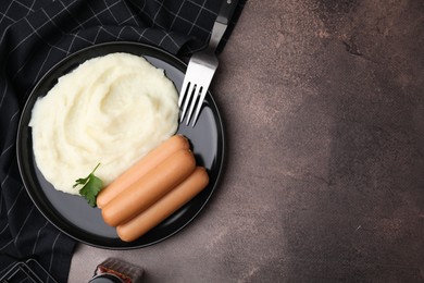 Photo of Delicious boiled sausages, mashed potato and parsley on brown table, top view. Space for text