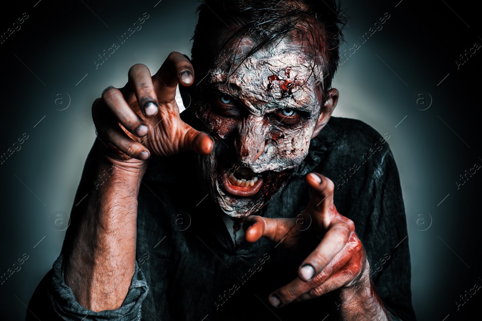 Photo of Scary zombie on dark background. Halloween monster