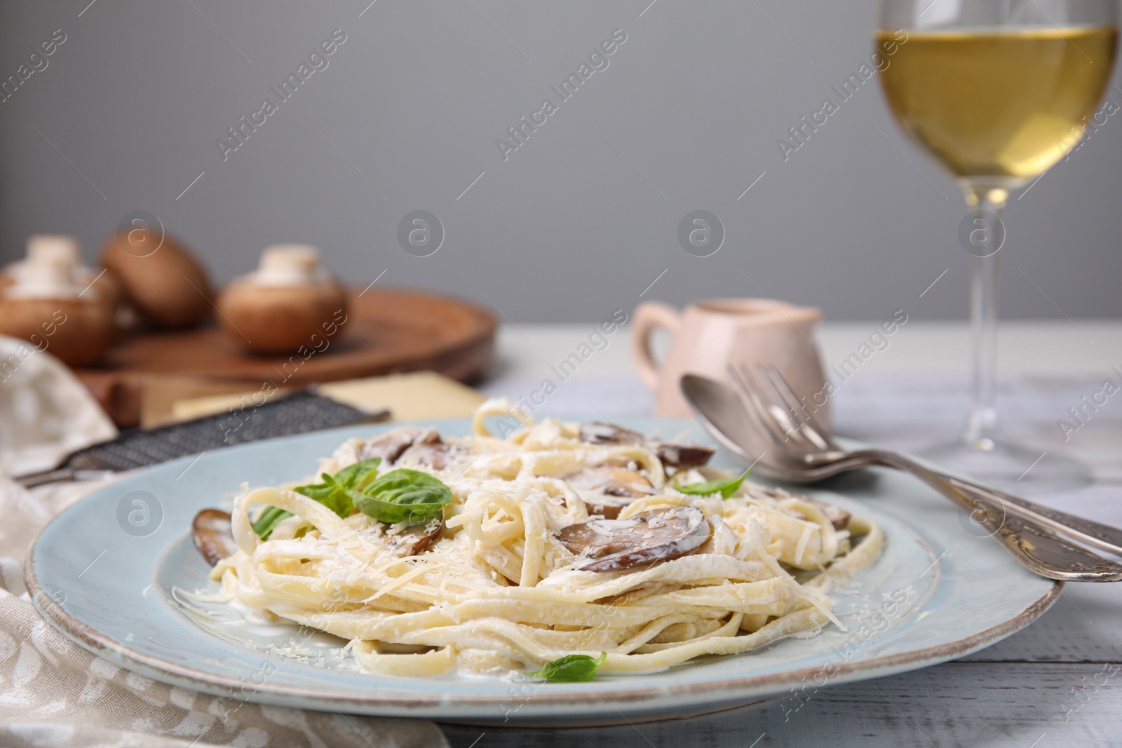 Photo of Delicious pasta with mushrooms and cheese on white wooden table, closeup