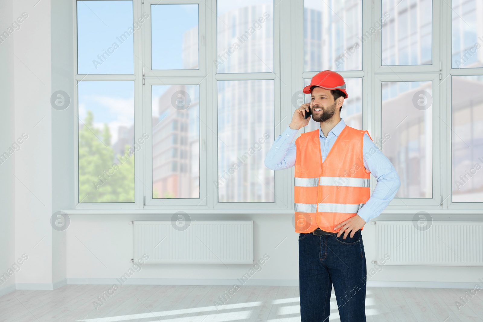Photo of Man in reflective uniform talking on phone indoors, space for text