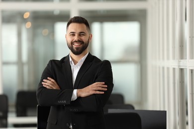 Portrait of smiling man with crossed arms in office, space for text. Lawyer, businessman, accountant or manager