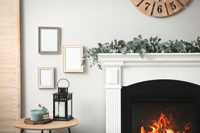 Beautiful garland with eucalyptus branches on fireplace in room