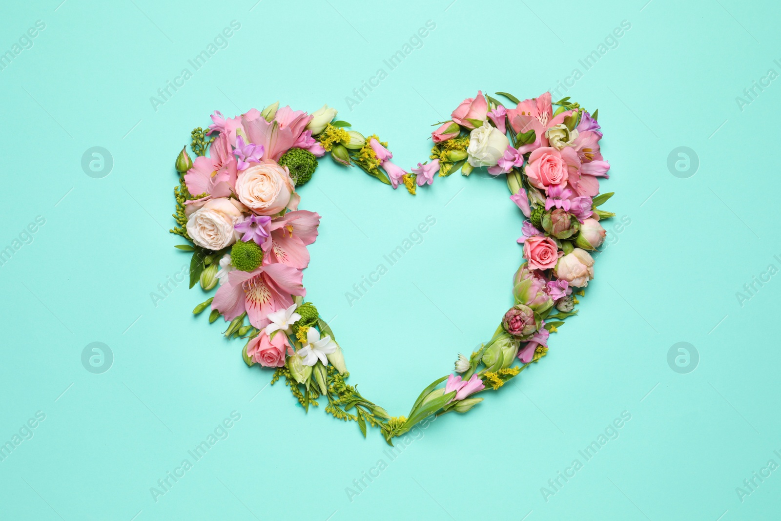 Photo of Beautiful heart shaped floral composition on turquoise background, flat lay