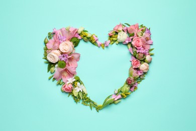 Photo of Beautiful heart shaped floral composition on turquoise background, flat lay