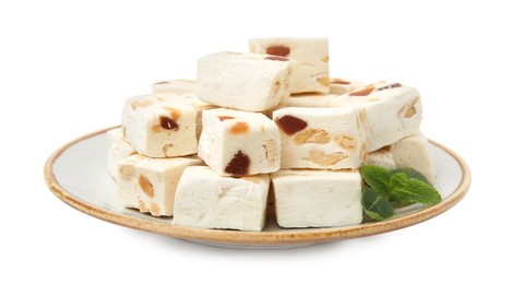 Photo of Plate with pieces of delicious nougat and mint isolated on white