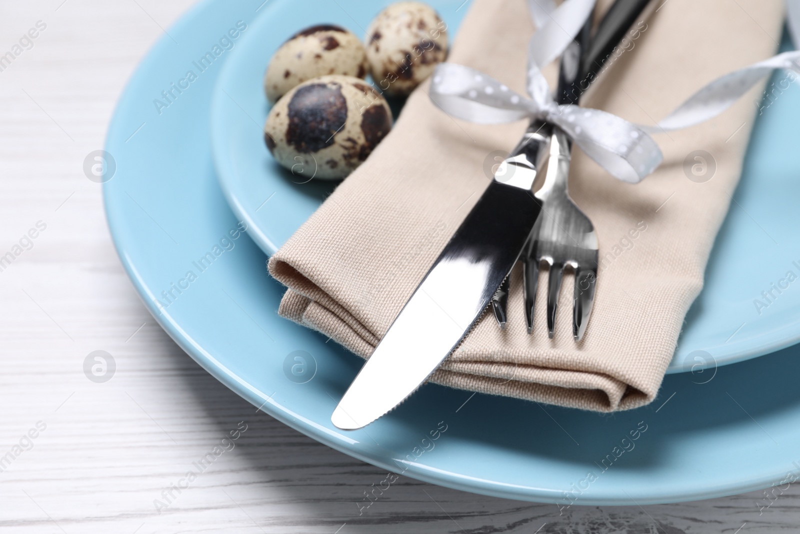 Photo of Festive Easter table setting with eggs on white wooden background, closeup