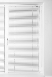 Photo of Modern window with closed stylish white blinds