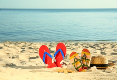 Composition with stylish beach accessories on sand near sea. Space for text