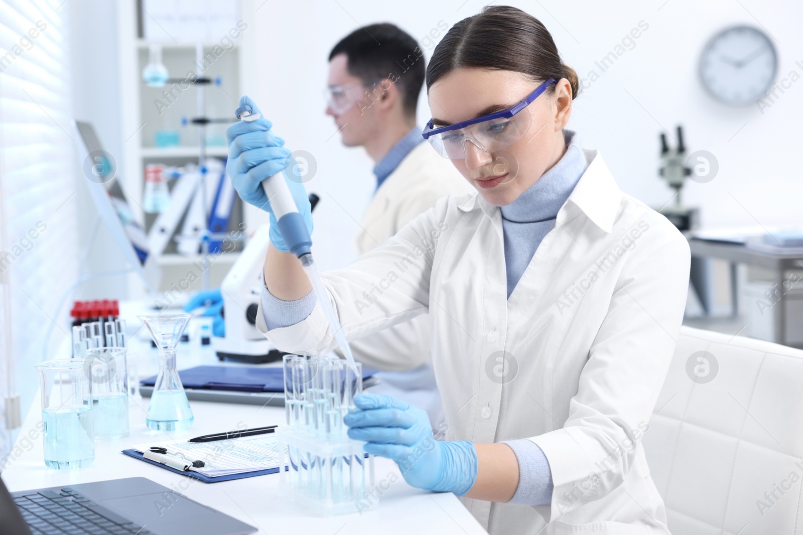 Photo of Scientist dripping sample into test tube in laboratory