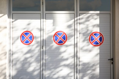 Photo of Signs No Stopping on white door outdoors