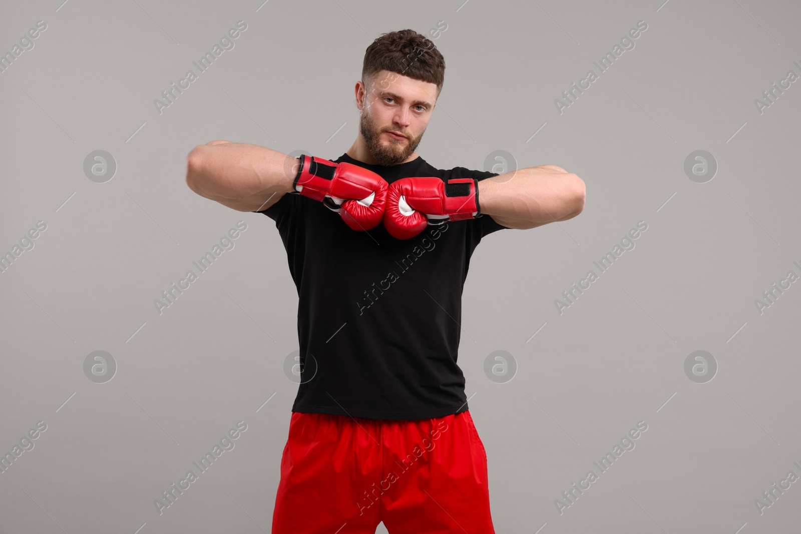 Photo of Man in boxing gloves on grey background